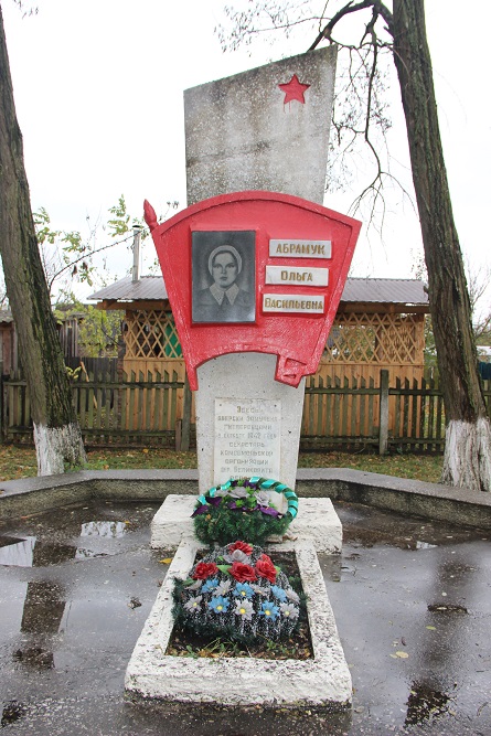 Мраморная стела с комсомольским значком на могиле Оли Абрамук.