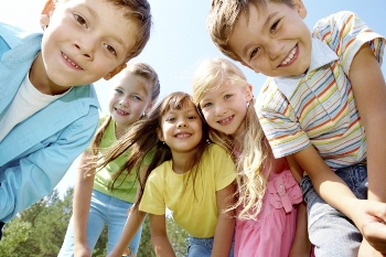 Группа улыбающихся детей в современной одежде.