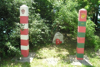 Два пограничных столба с памятным камнем между ними. Фотография.