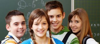 Подростки стоят у школьной доски.