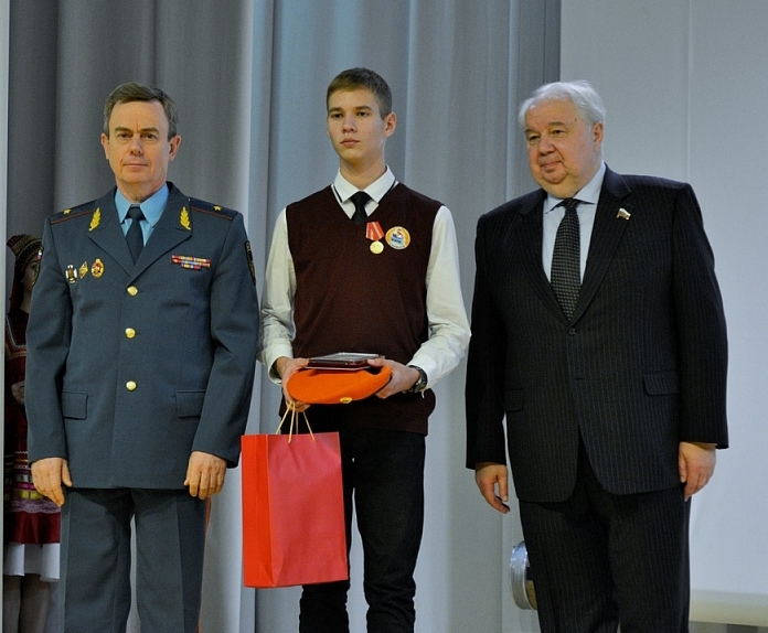 Кирилл Абрамов стоит на сцене с сотрудниками МЧС.